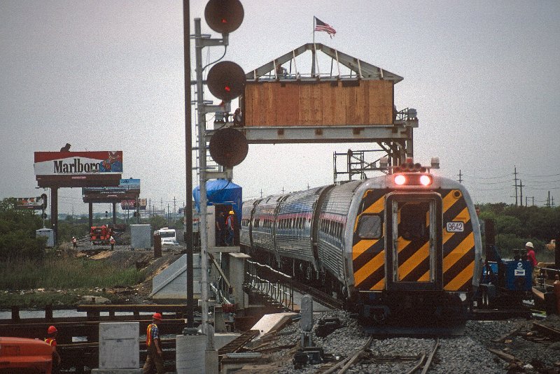 19809311-amtk.jpg - May 22, 1989: The inaugural train from Washington, DC, crosses the still-under-construction bridge over the Intracoastal Waterway. Note the Amtrak billboard partially hidded by the Marlboro Man.
