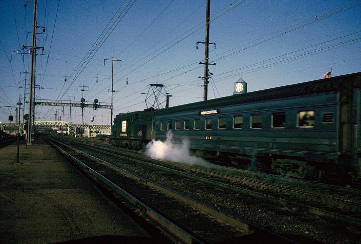 fp10.jpg - A westbound PC train passes through Frankford Junction in the pre-Amtrak days.  The Frankford elevated bridge in the in the background. Notice the different company logo on the watertower in the next photo.