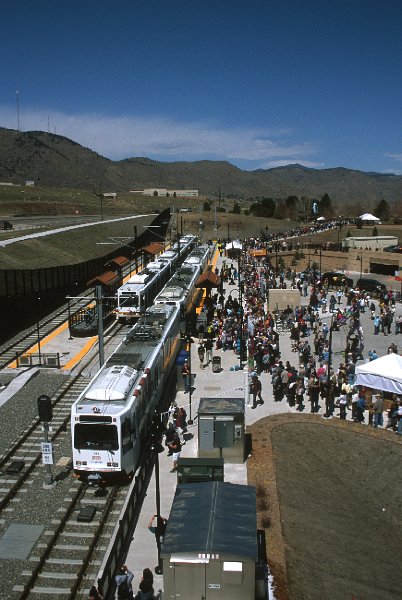 20130165-rtd.jpg - Opening Ceremonies are over and the VIP train is leaving the Jefferson County Government Center-Golden Station for Denver, Union Station. The crowd of people awaiting free rides on the just-opened line fill the sidewalk. (4/26/13)