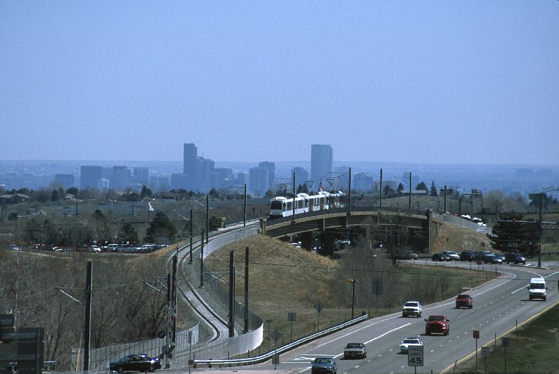 20130166-rtd.jpg - An outbound train passes over the West Colfax Ave. bridge in Golden. The Denver skyline is visible in the background, and the vast flatness of the eastern half of Colorado beyond.  (4/26/13)