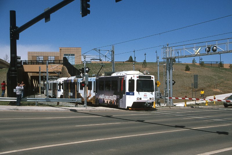 20130167-rtd.jpg - A three-car train full of happy first-day riders crosses Johnson Road after passing under the parking garage at the Jefferson County Government Center-Golden Station.  The passage under the garage was built to accommodate an eventual double tracking of the line between Golden and Federal Center stations. (4/26/13)